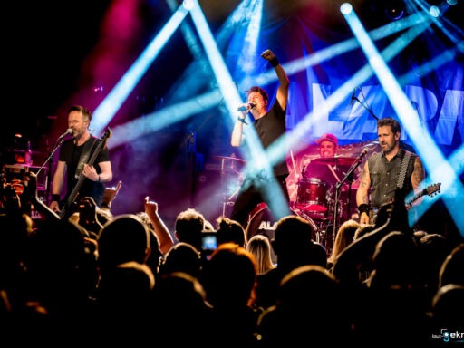 Live-Bandauftritt mit Scheinwerferlichtern auf Bühne.