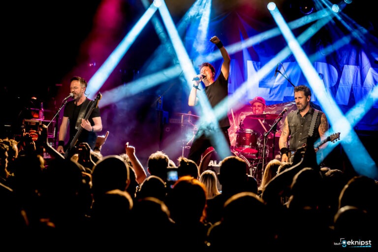 Live-Bandauftritt mit Scheinwerferlichtern auf Bühne.