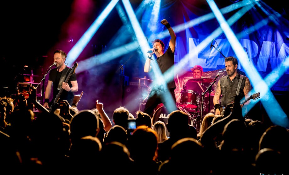 Live-Bandauftritt mit Scheinwerferlichtern auf Bühne.