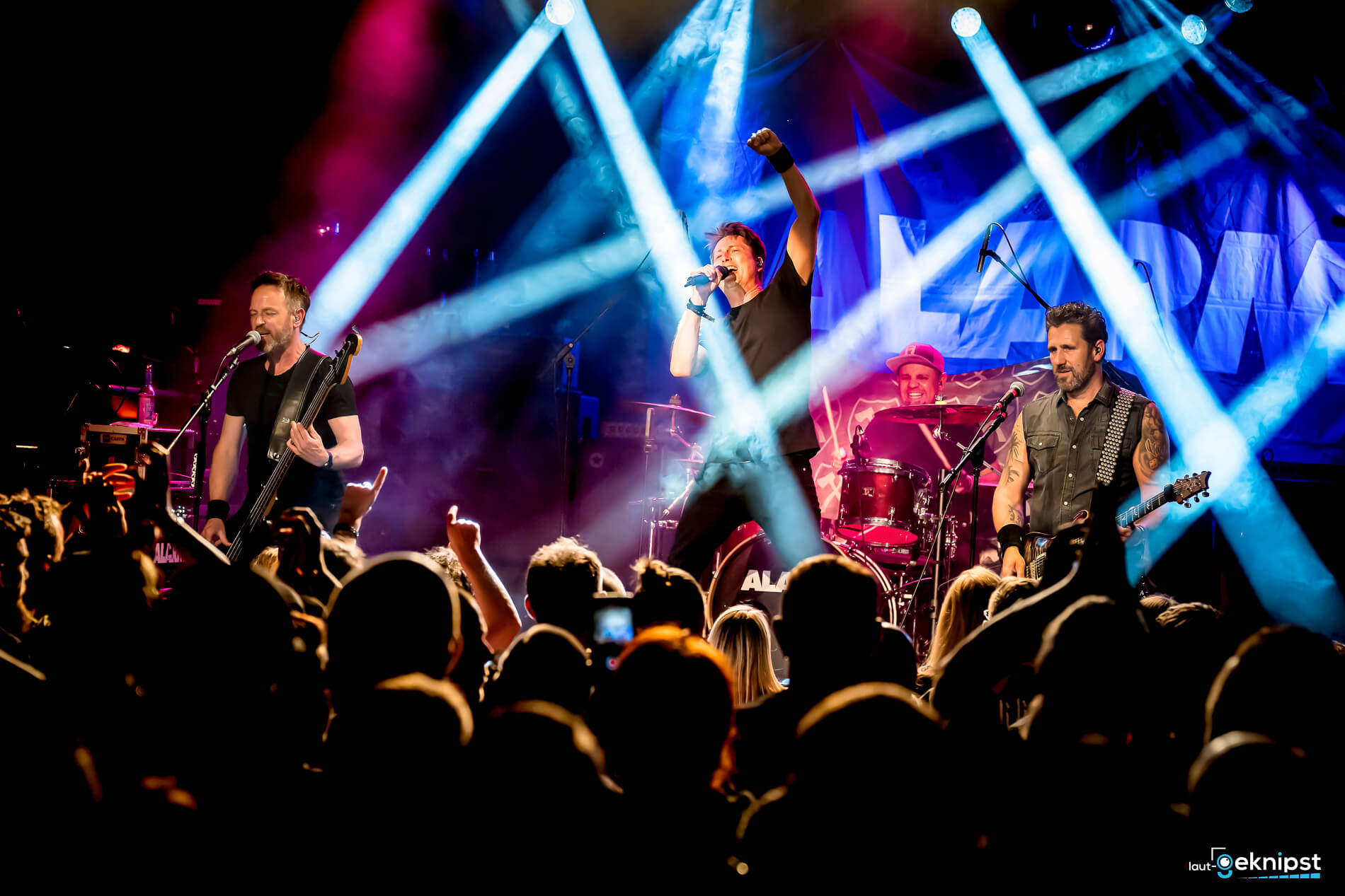 Live-Bandauftritt mit Scheinwerferlichtern auf Bühne.