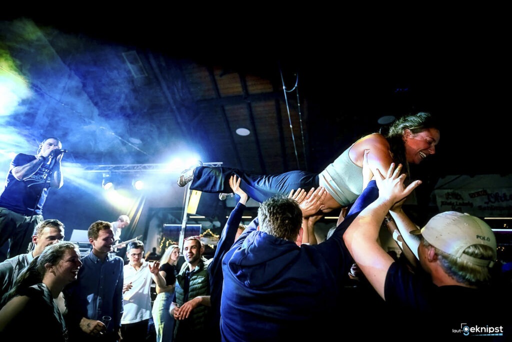 Frau wird beim Konzert von Menschen getragen.