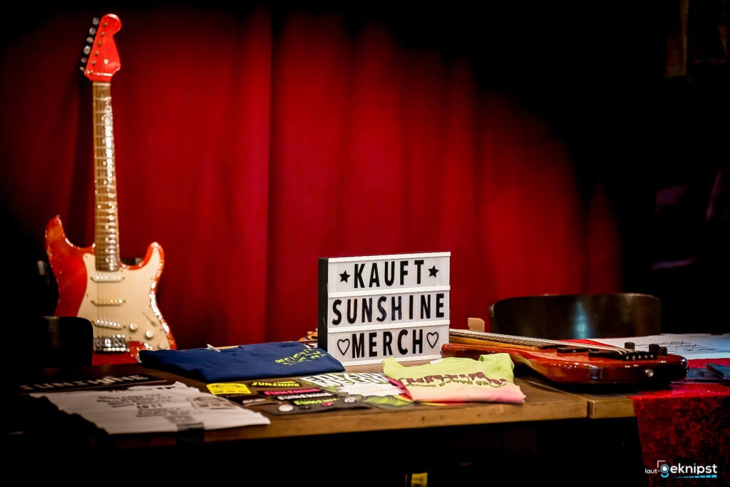 Merchandise-Tisch mit Gitarre und Lichtbox