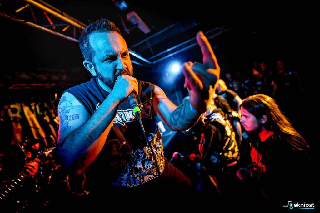 Mann singt in einem Rockkonzert auf Bühne.
