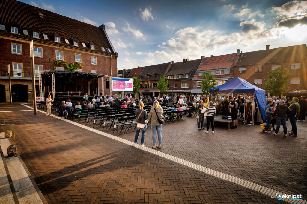 Open-Air-Veranstaltung auf einem Platz mit vielen Menschen.