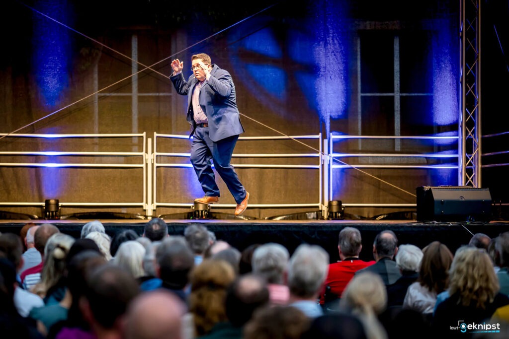 Mann auf Bühne springt vor Publikum