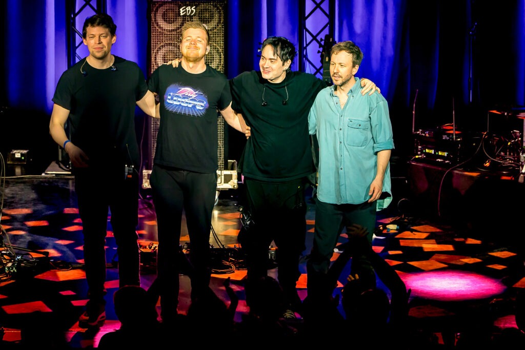 Band steht auf einer Bühne.
