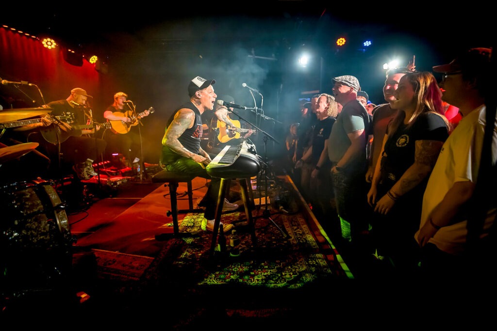 Band spielt Konzert vor Publikum auf Bühne.