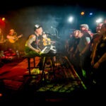 Band spielt Konzert vor Publikum auf Bühne.