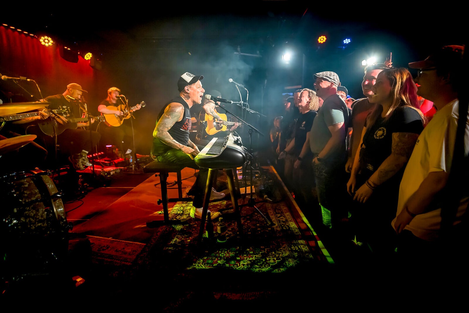 Band spielt Konzert vor Publikum auf Bühne.