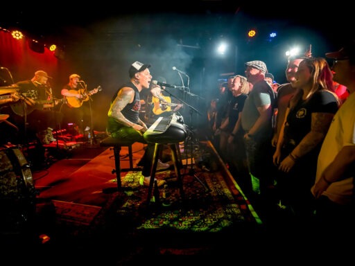 Band spielt Konzert vor Publikum auf Bühne.