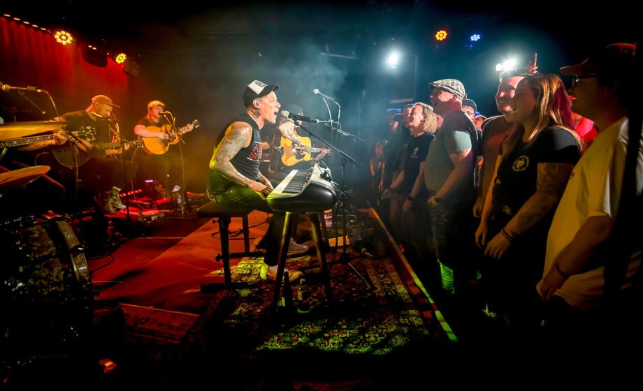 Band spielt Konzert vor Publikum auf Bühne.