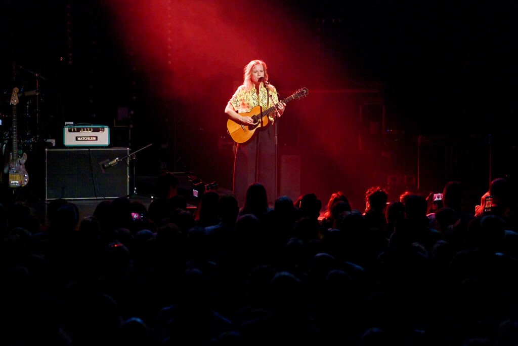 Konzert: Musikerin mit Gitarre im Rampenlicht