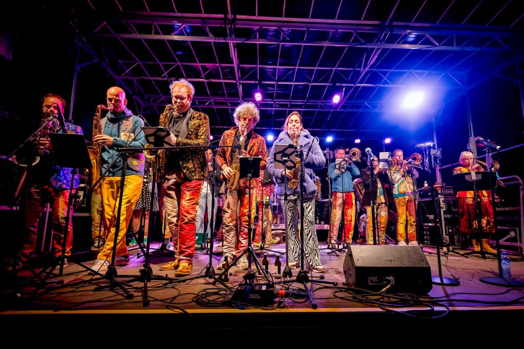 Bunt gekleidete Band spielt auf einer Bühne