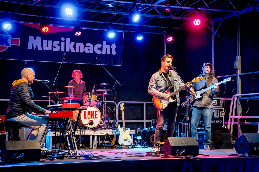 Band spielt bei Nachtkonzert auf einer Bühne.