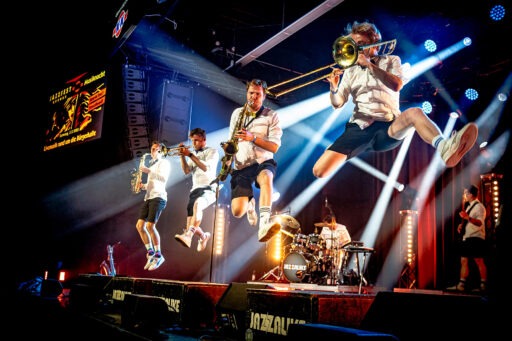 Band springt während Konzert auf der Bühne