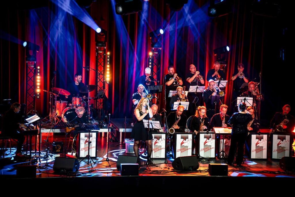 Bigband auf Bühne mit Sängerin und Lichtshow
