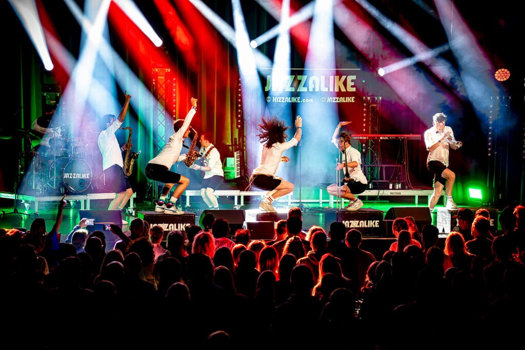 Musikband performt auf Bühne mit Lichteffekten.