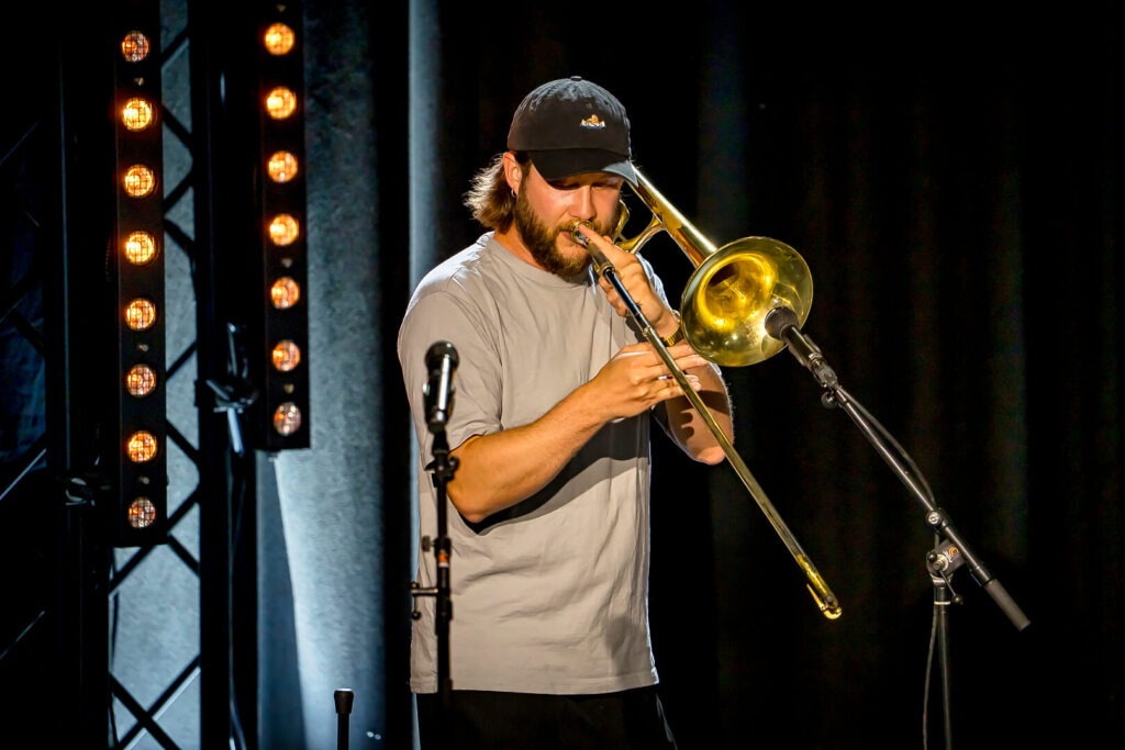 Musiker spielt Posaune auf der Bühne.