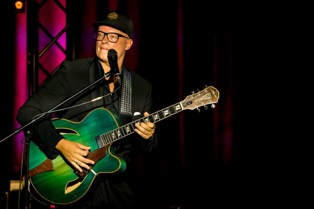 Musiker mit Gitarre auf Bühne
