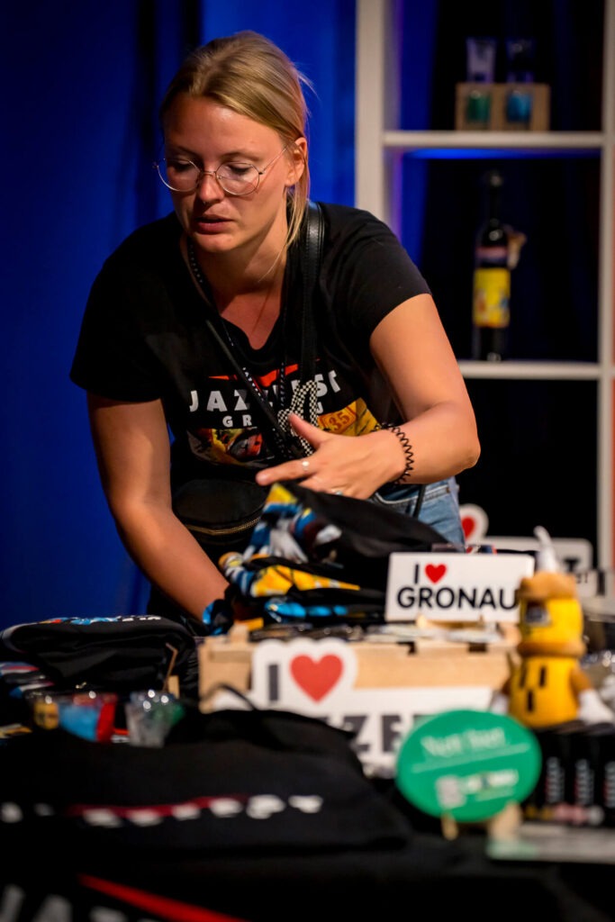 Frau an einem Souvenirstand mit Gronau-Artikel