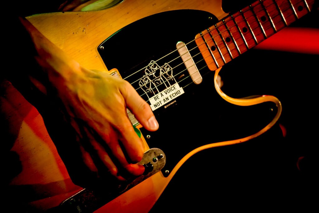 Hand spielt Gitarre mit Aufkleber