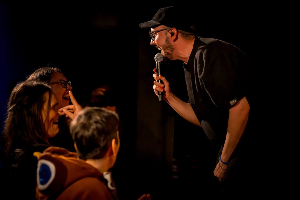 Comedian lacht mit Publikum auf der Bühne