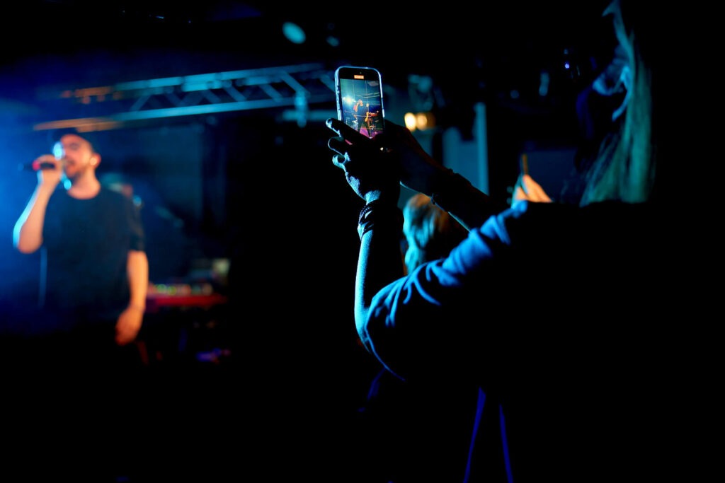Person filmt Konzert mit Handy