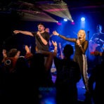 Konzert mit Sänger und Band auf der Bühne.