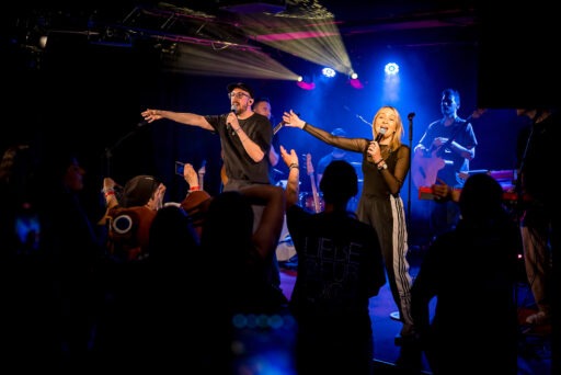 Konzert mit Sänger und Band auf der Bühne.