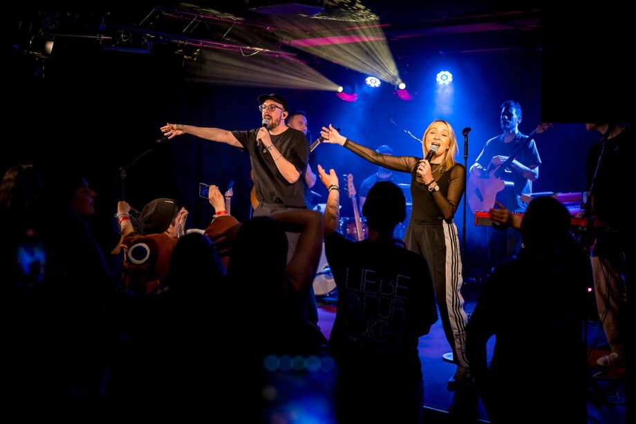 Konzert mit Sänger und Band auf der Bühne.