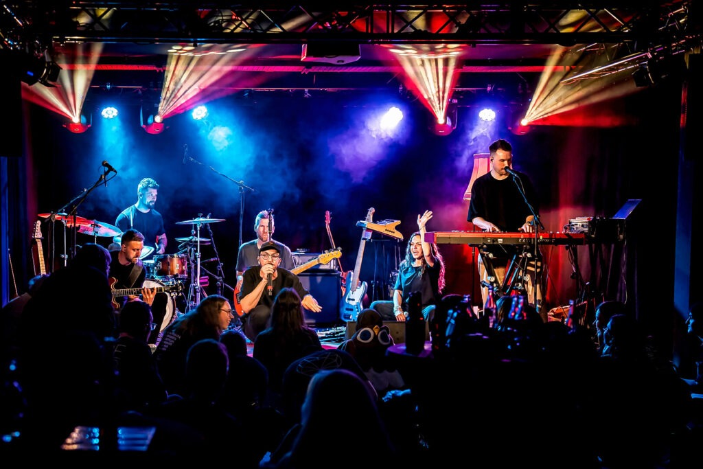 Live-Musikband auf der Bühne mit Lichteffekten.