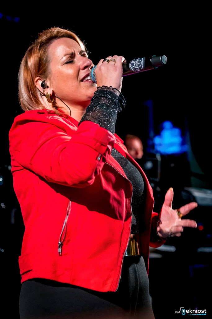 Frau singt auf der Bühne, rotes Outfit