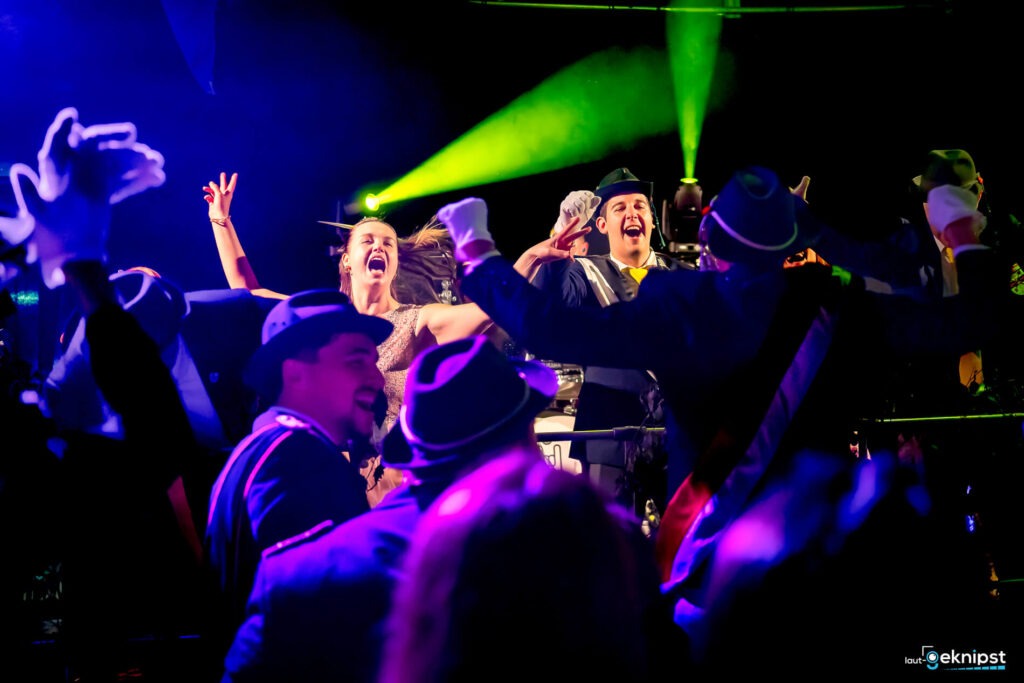 Party mit tanzenden Gästen unter bunten Lichtern