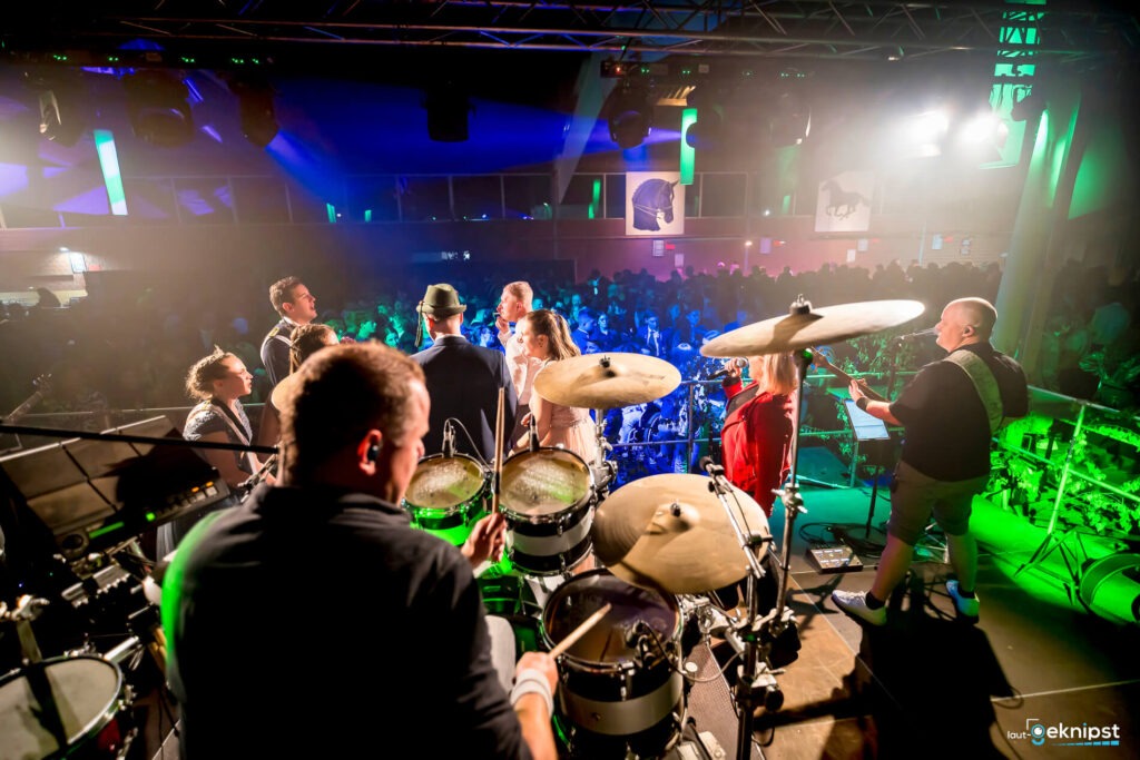 Band spielt auf einer Bühne vor Publikum.