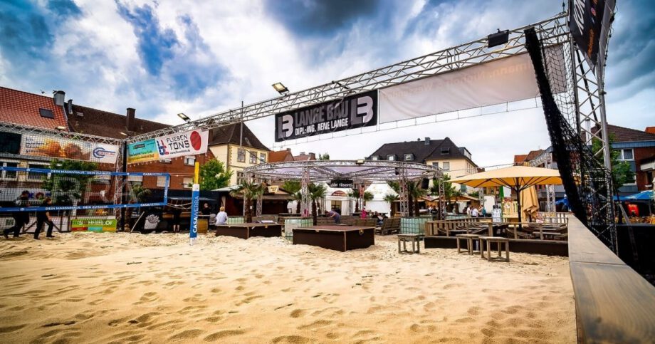 Städtisches Strandcafé mit Volleyballplatz und Sitzbereich.