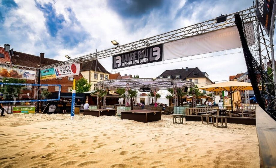 Städtisches Strandcafé mit Volleyballplatz und Sitzbereich.