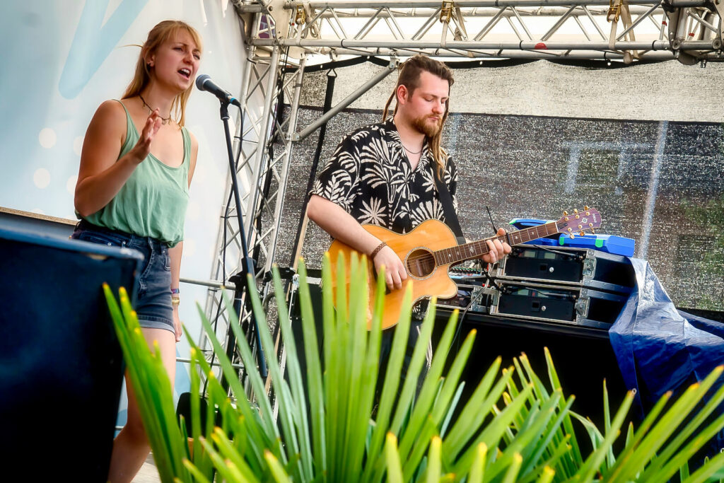 Musikerduo mit Gitarre auf Bühne.