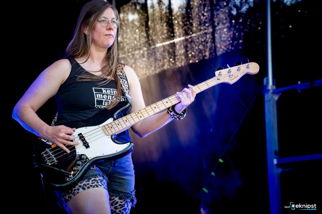 Frau spielt Bass auf der Bühne