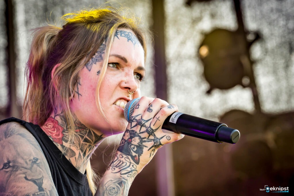 Tattooierte Sängerin mit Mikrofon auf Bühne