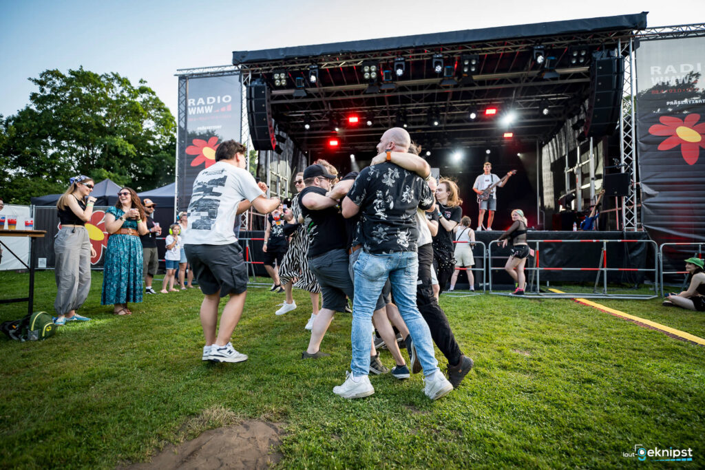 Menschen tanzen vor der Bühne beim Open-Air-Konzert.