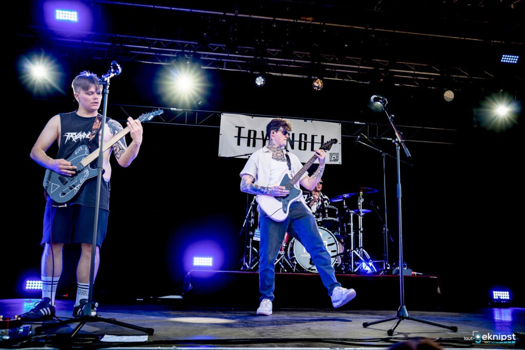 Band spielt Live-Konzert auf Bühne mit Gitarren.