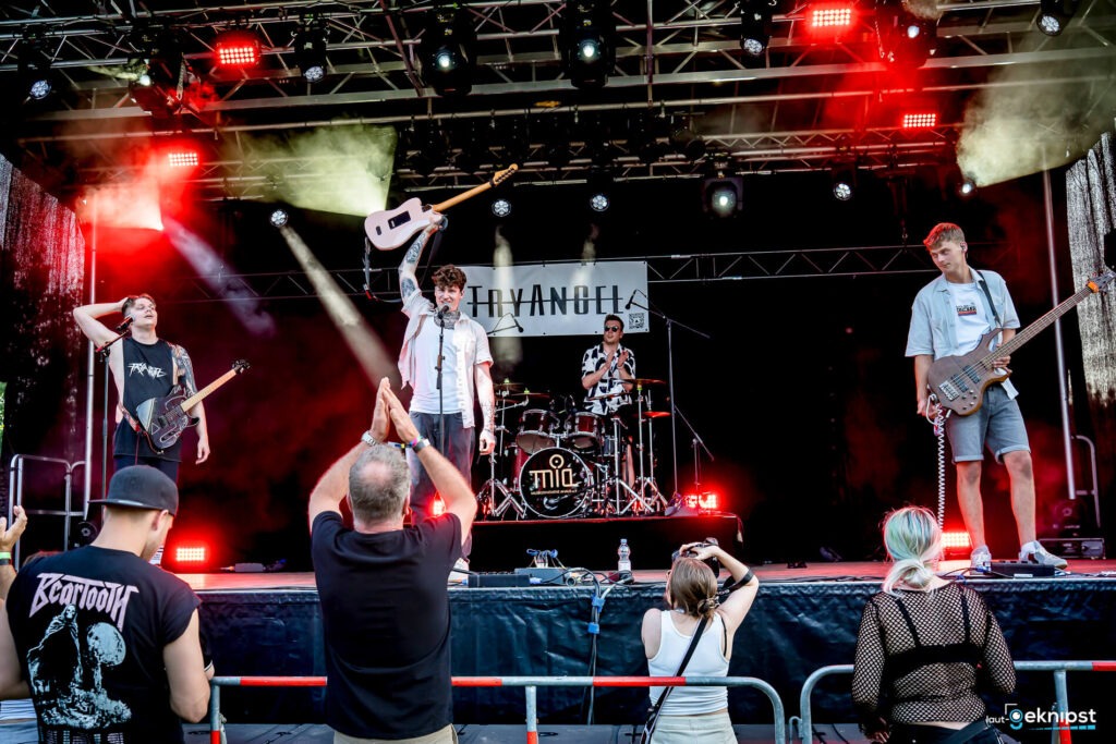 Bandauftritt auf Open-Air-Bühne mit jubelndem Publikum.
