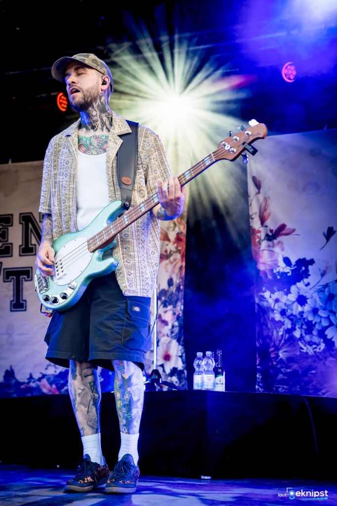 Bassist spielt live auf der Bühne mit Lichteffekten.