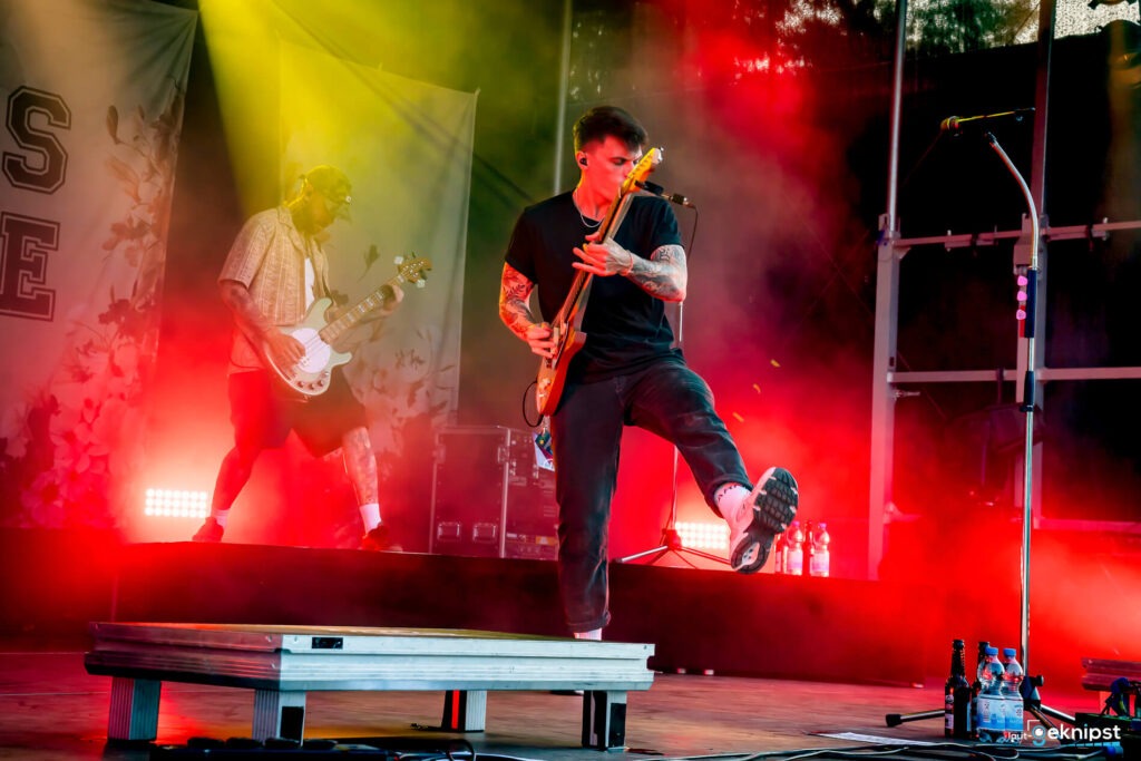Musiker auf der Bühne mit Gitarren, bunte Lichter