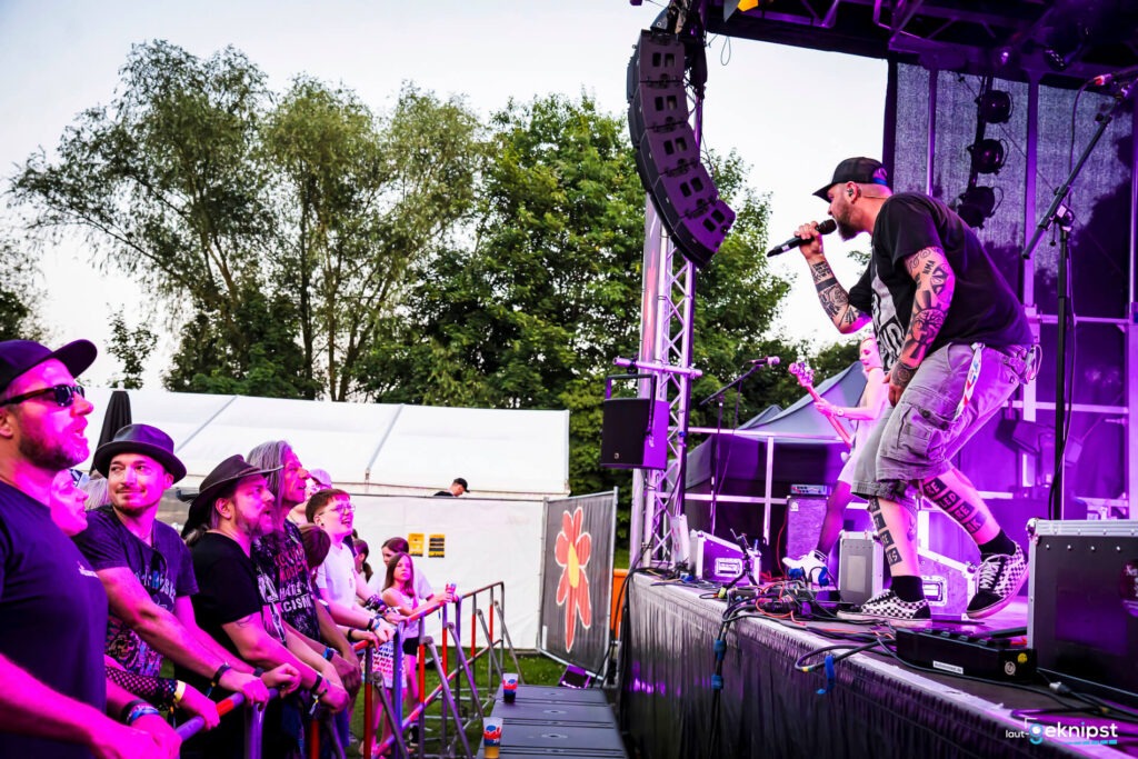 Sänger performt auf Open-Air-Bühne vor Publikum