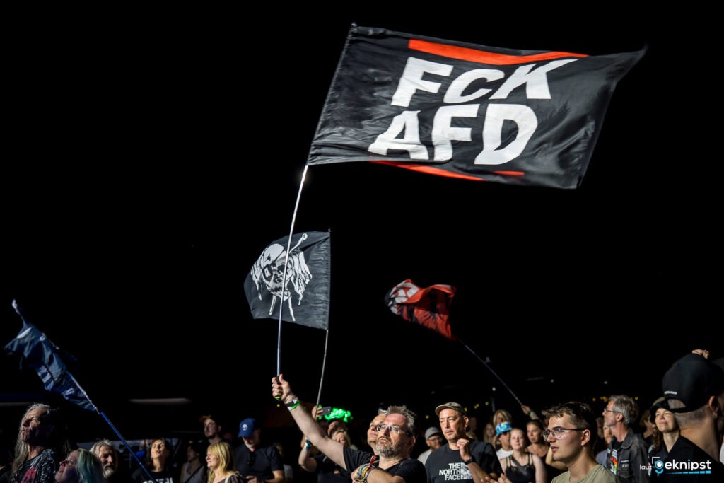 Menschen mit Flaggen auf Protest bei Nacht.