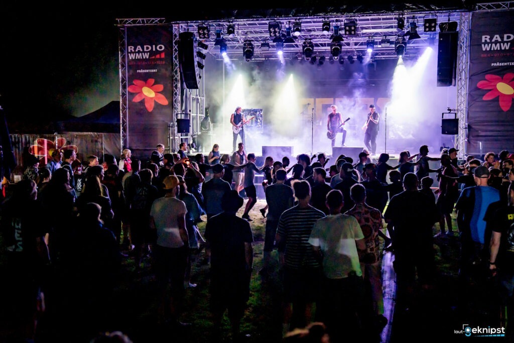 Konzert mit Menschenmenge und Bühne bei Nacht