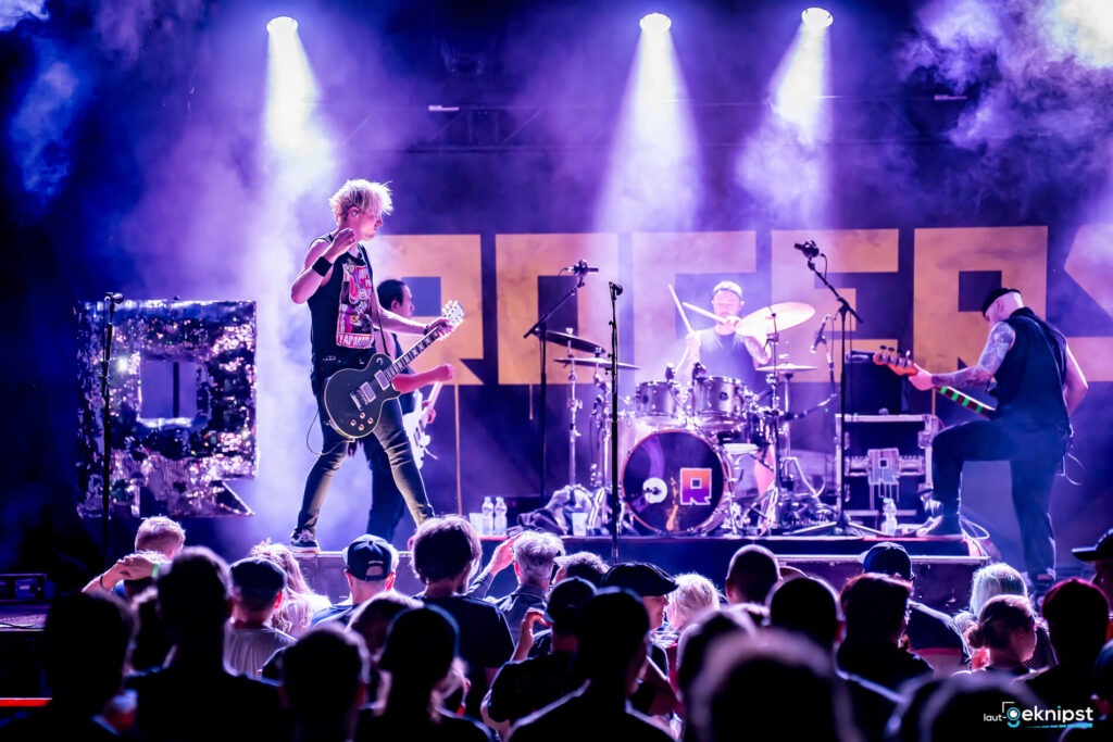 Rockband spielt auf der Bühne vor Publikum.