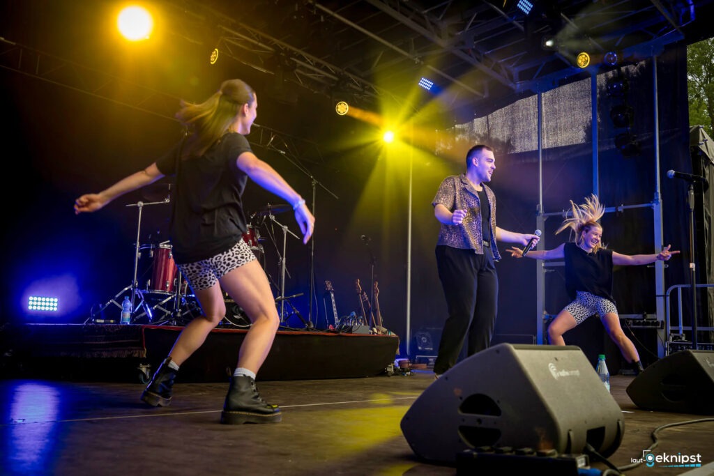 Konzert: Drei Personen tanzen auf der Bühne.