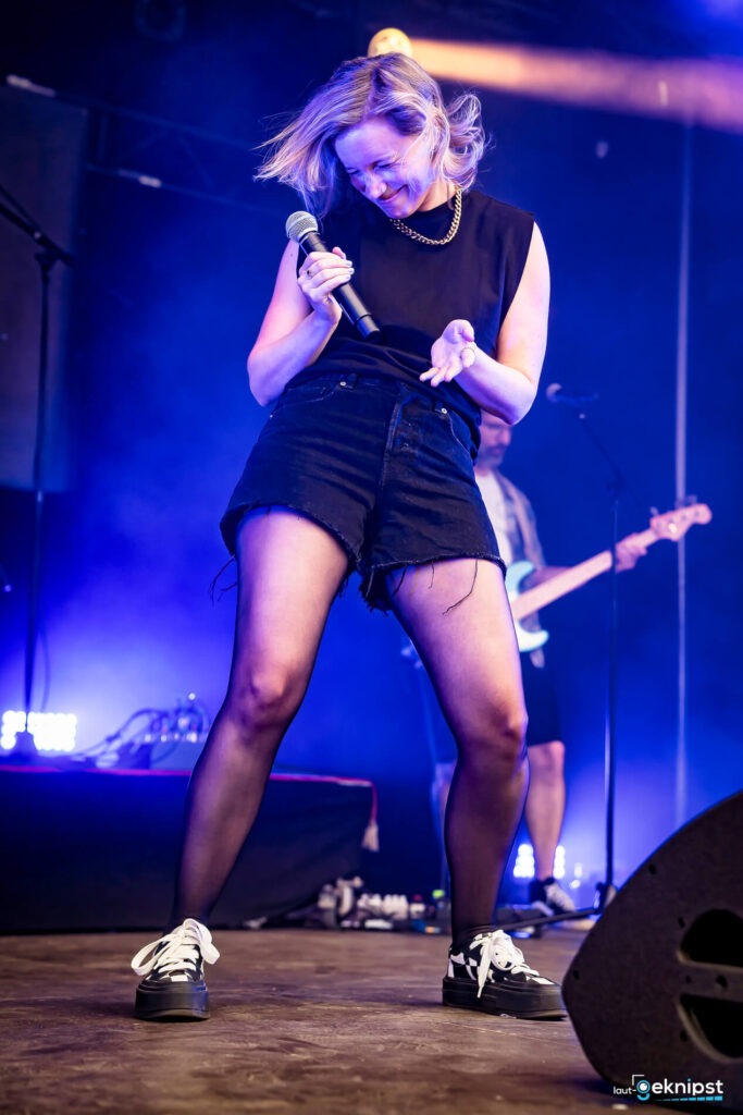 Frau singt auf Bühne beim Konzert